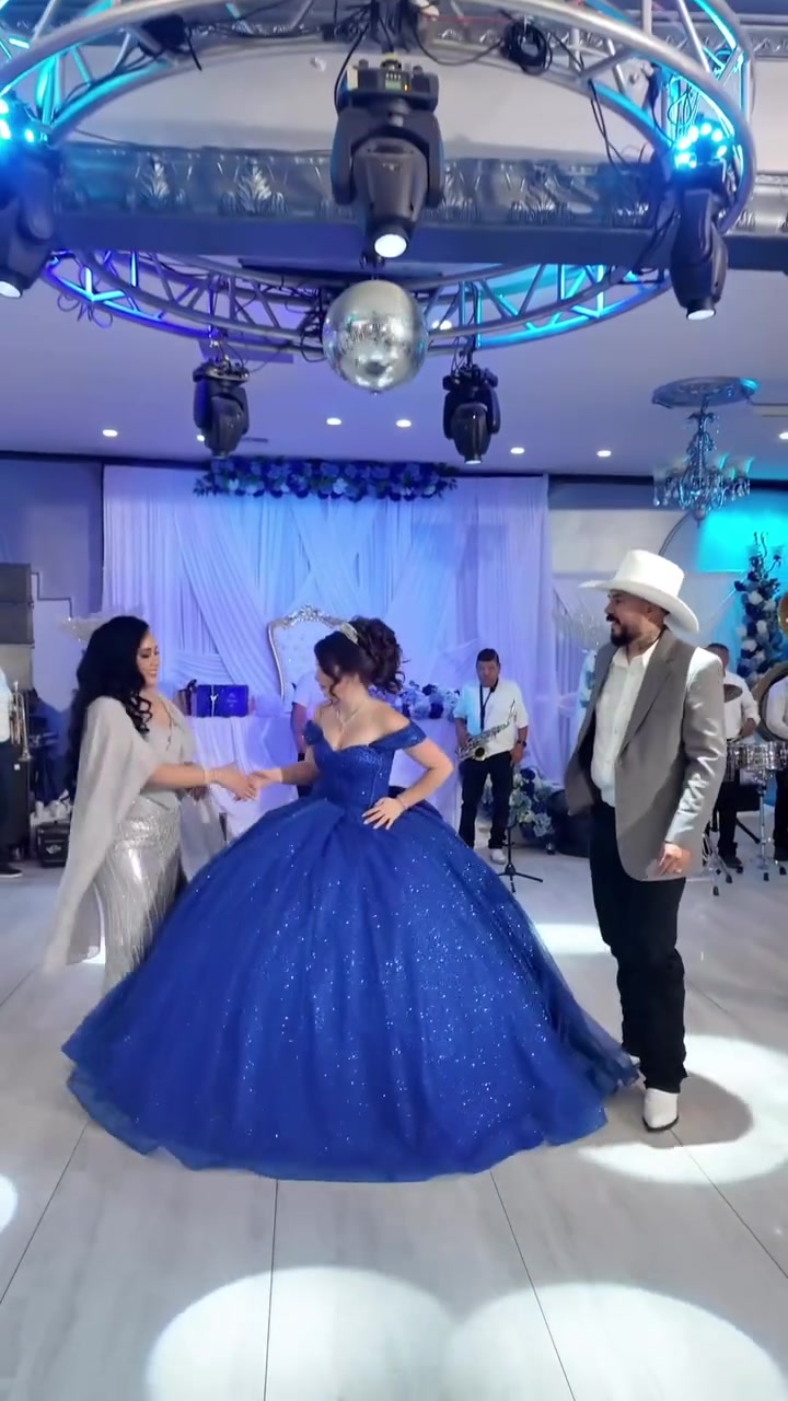 A quinceañera dancing with her family in the hall